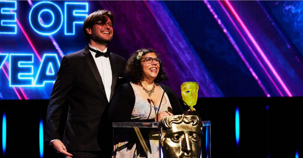 Photo of Witch Beam’s Tim Dawson and Wren Brier accepting BAFTA Games Award for Unpacking.