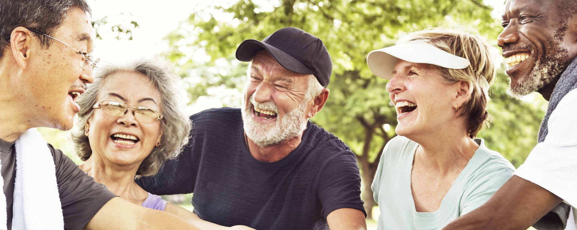 Laughing group of elderly people coming together in park