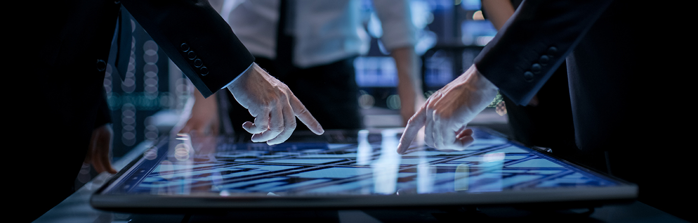 Businessmen using touch screen on tabletop