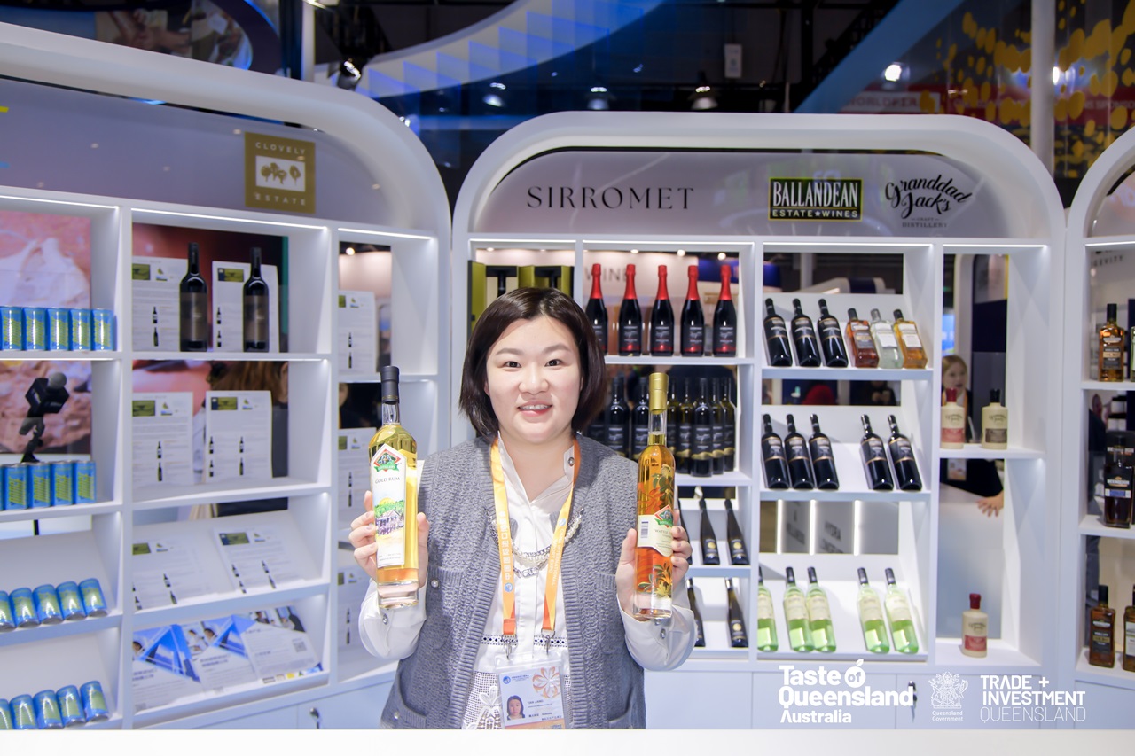 A lady at CIIE 2024 holding bottles of alcohol.