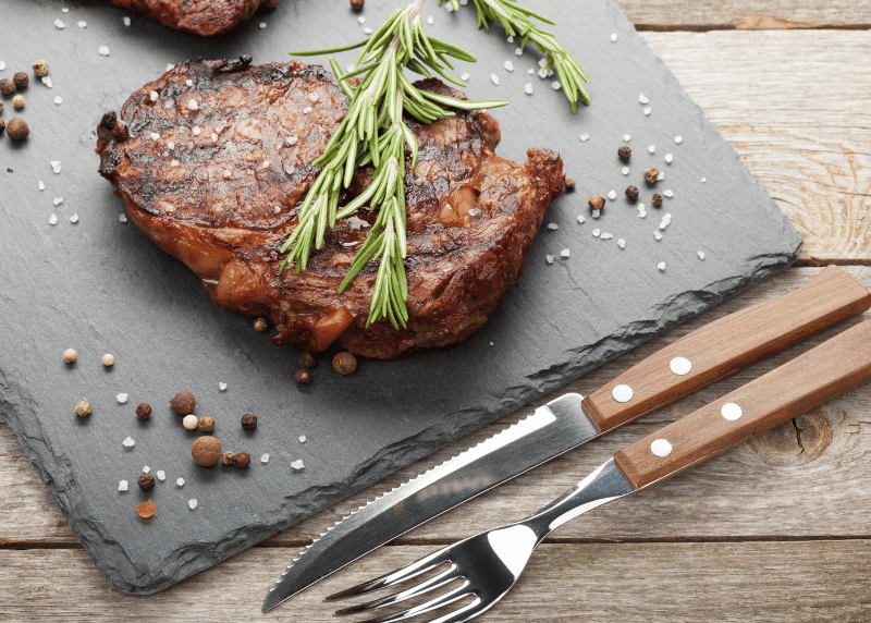 Steak on a slated plate with a knife and fork